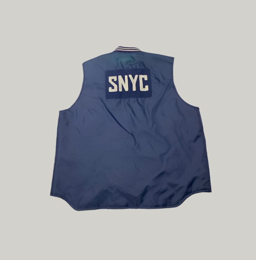 Blue vest with 'SNYC' logo on a light background