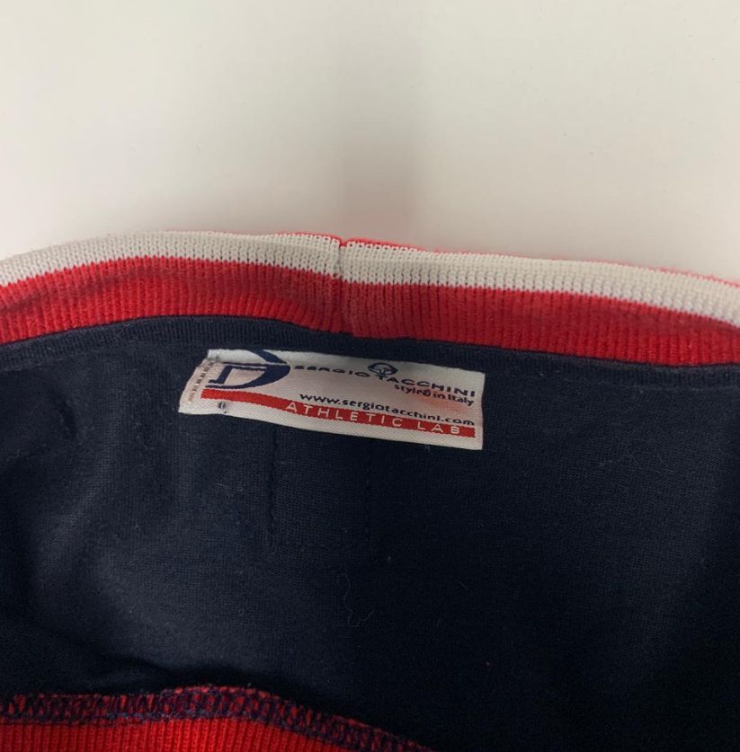 Close-up of a label on a piece of clothing with red and white trim.