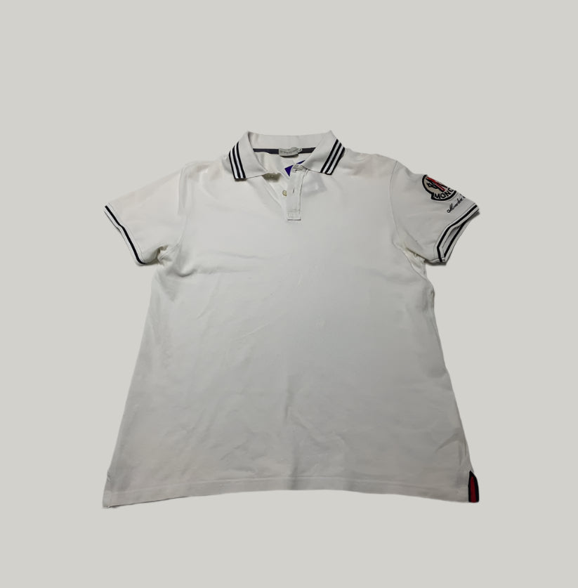 White polo shirt with black trim on a light gray background