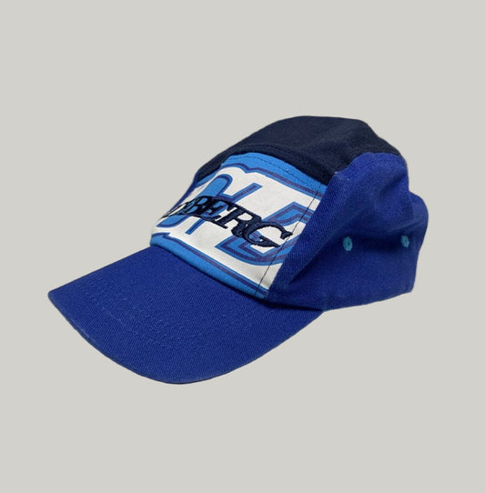 Blue cap with white logo on a light surface