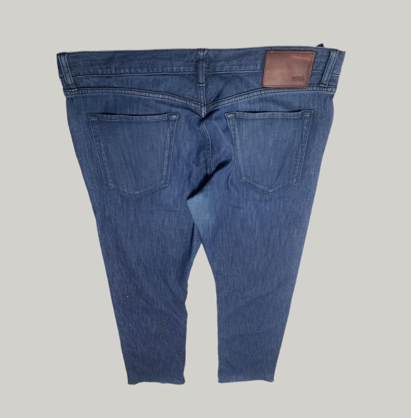 Blue jeans displayed on a white surface with a gray background
