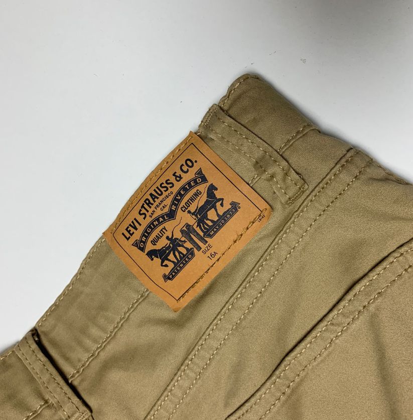 Levi's brand label on a beige pants back pocket against a white background