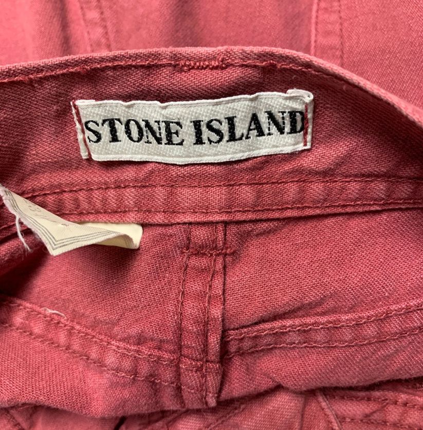 Close-up of a Stone Island label on a red garment.