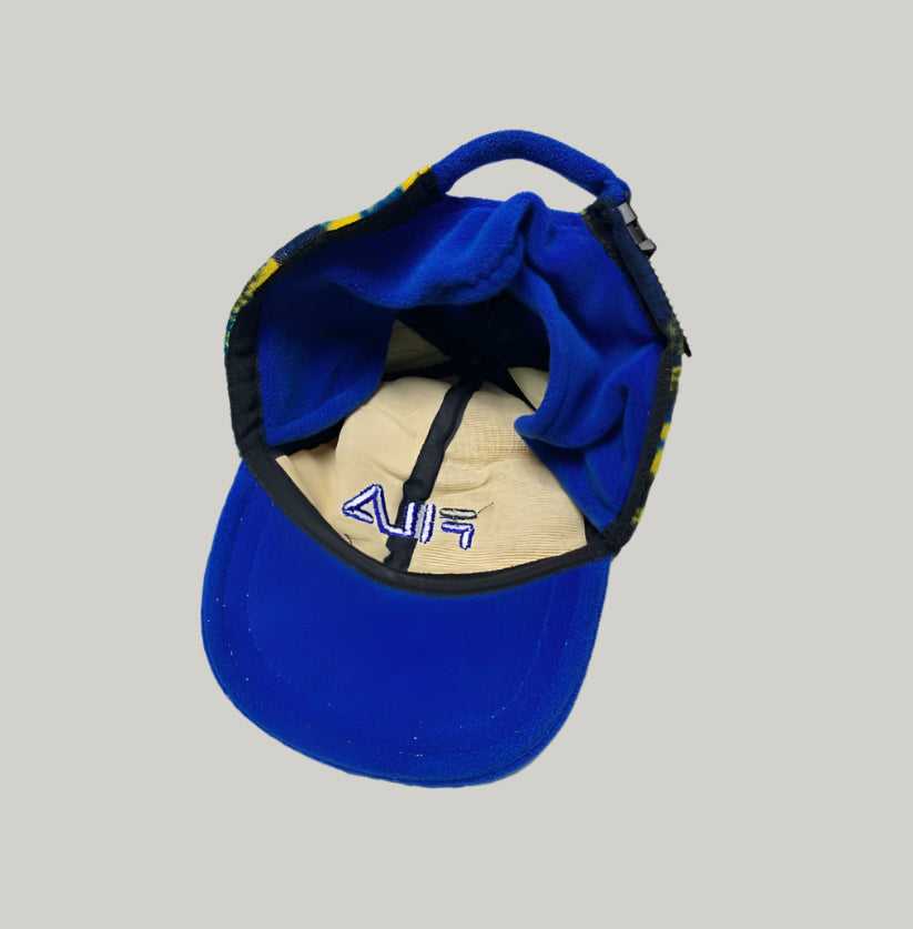 Blue cap with a visible brand logo on a light gray background