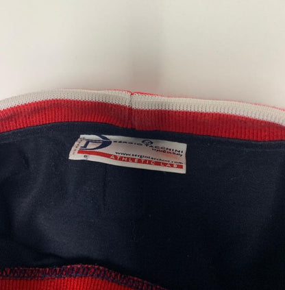 Close-up of a label on a piece of clothing with red and white trim.